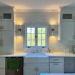 Bright kitchen with white cabinets, natural light, and modern fixtures.
