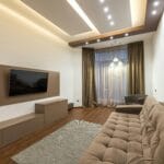 Spacious living room featuring modern design with cozy furniture and warm lighting.